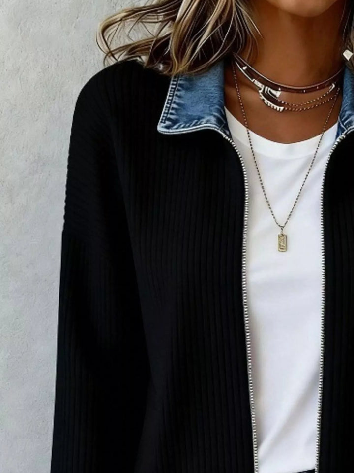 Close-up of black ribbed knit jacket with open zip and denim collar