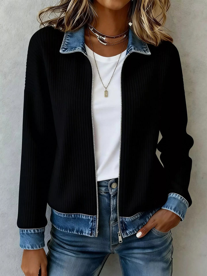 Black zip front ribbed knit jacket with denim collar and cuffs, hand in pocket