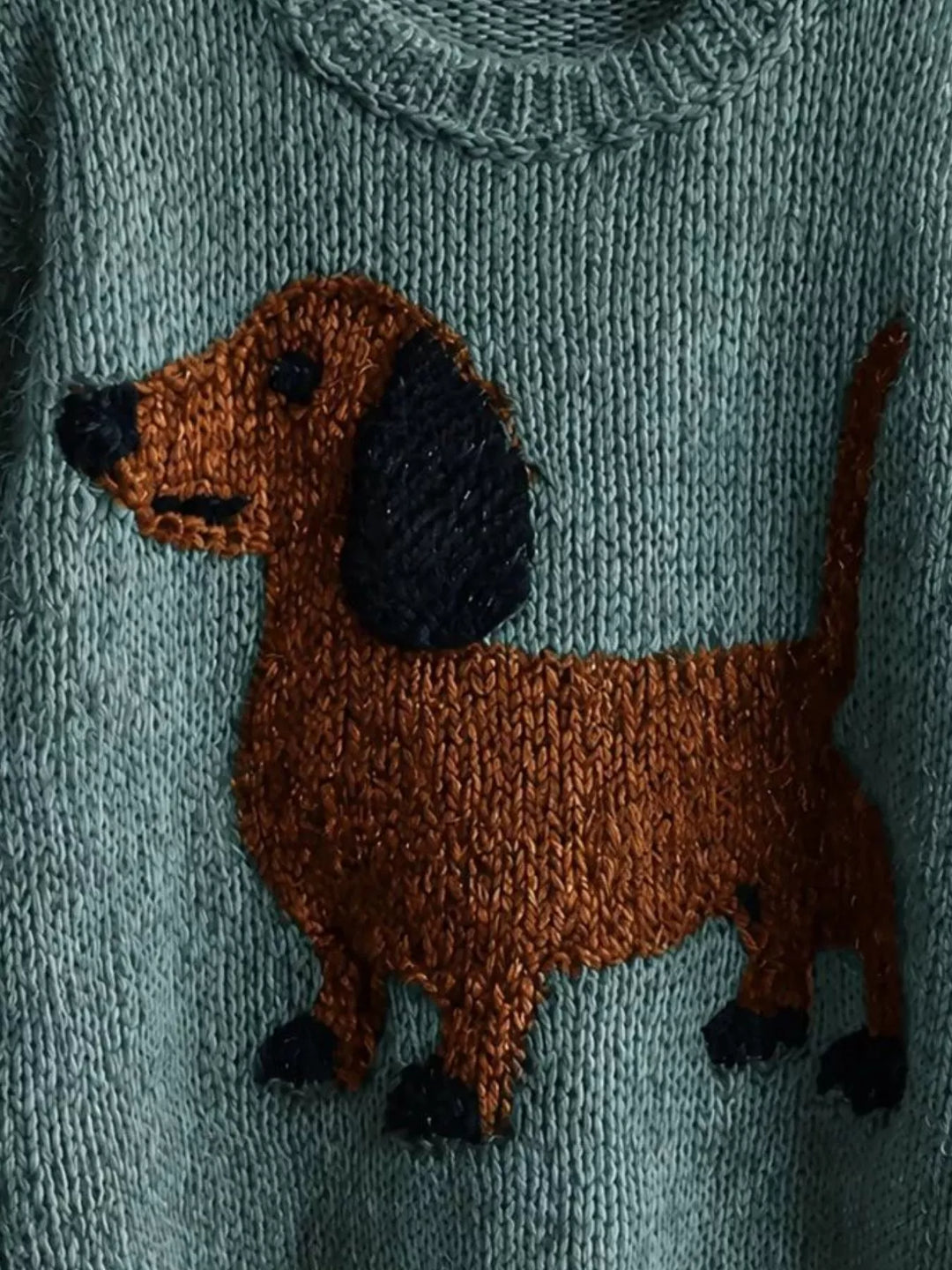 Close-up of the dachshund design and neckline on the teal knit sweater