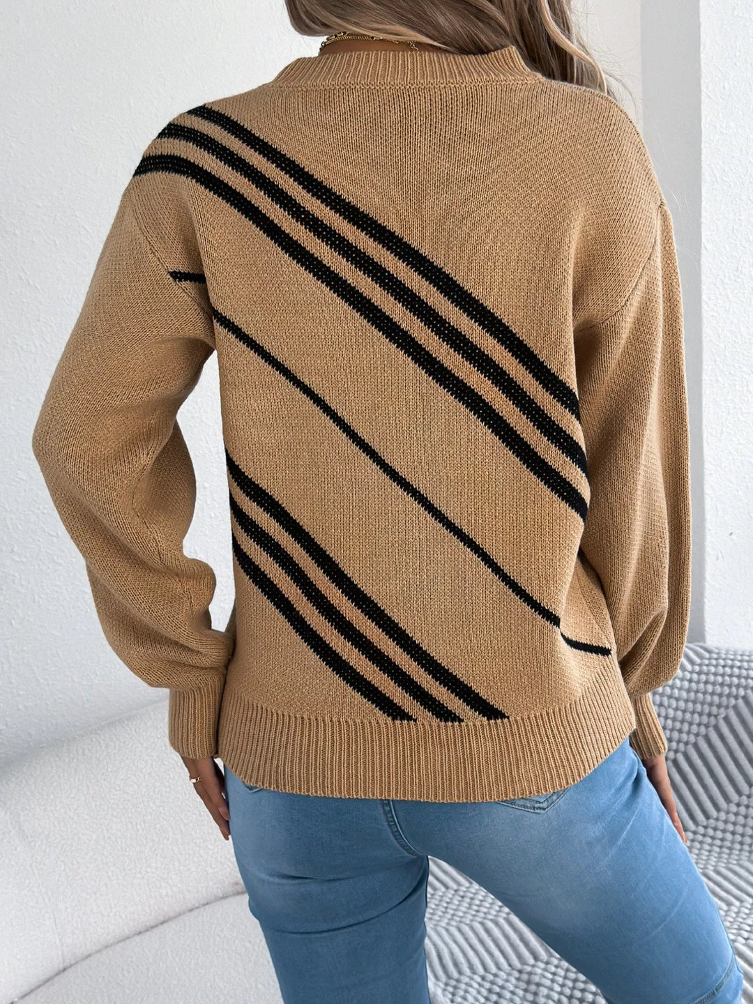 Back view of the camel crew neck sweater with bold black diagonal stripes