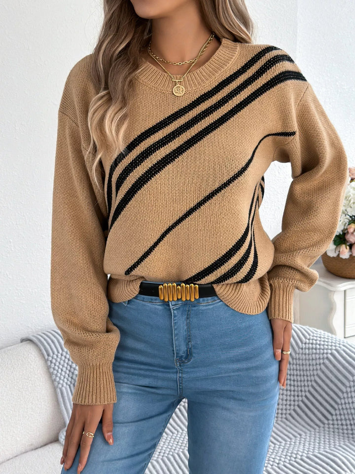 Camel crew neck sweater with hand on hip, black diagonal stripes, front view