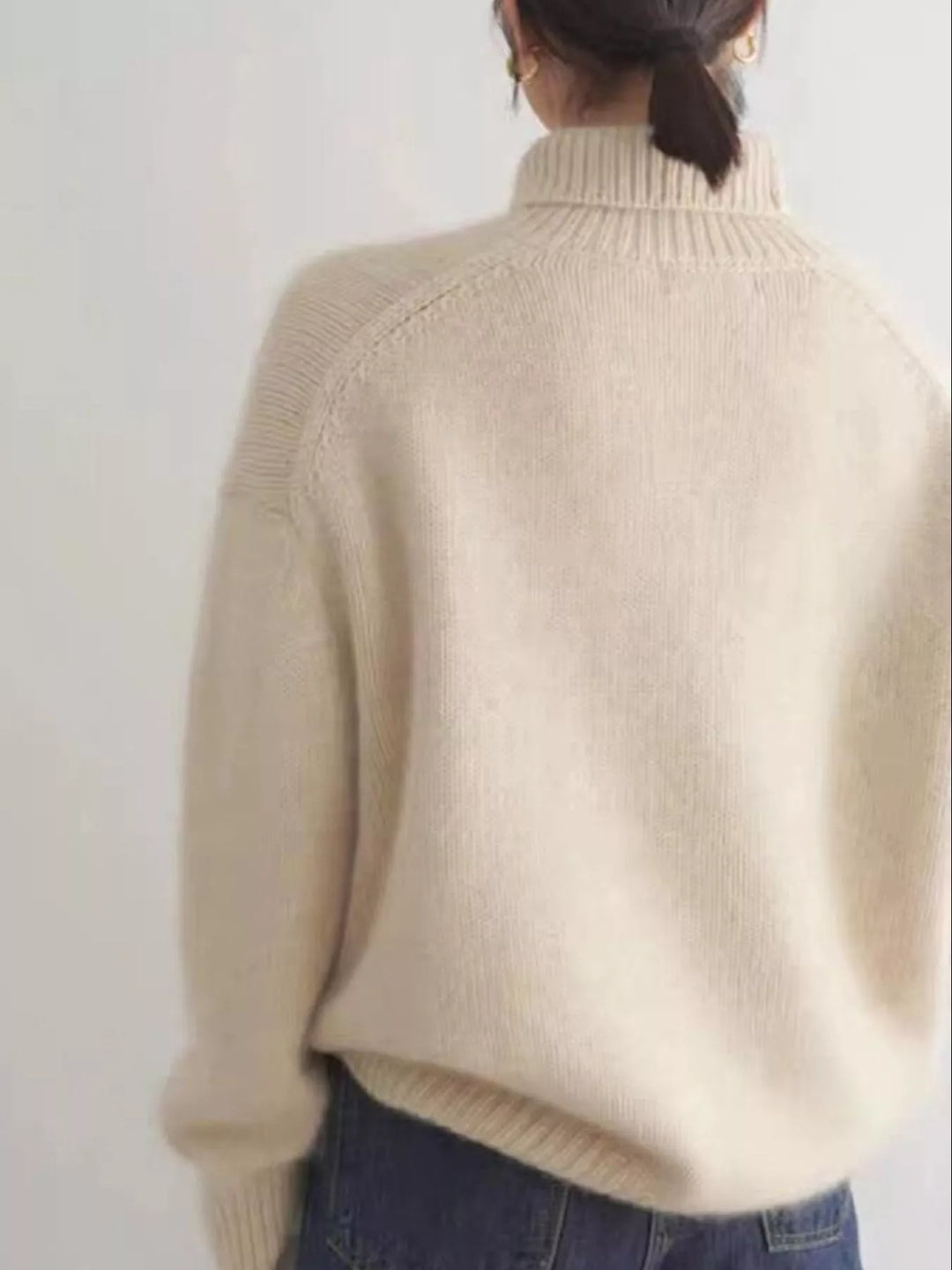 Back view of the cream turtleneck sweater with dropped shoulders