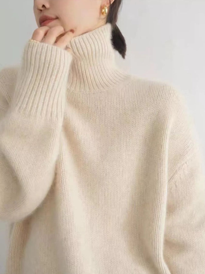 Hand at collar showing the cream fuzzy turtleneck and ribbed sleeve