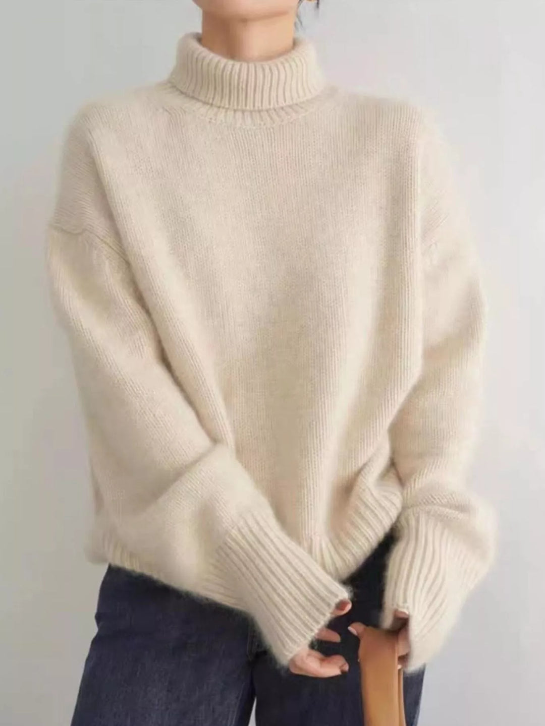 Women's fall sweater in cream with fuzzy turtleneck, worn with dark jeans