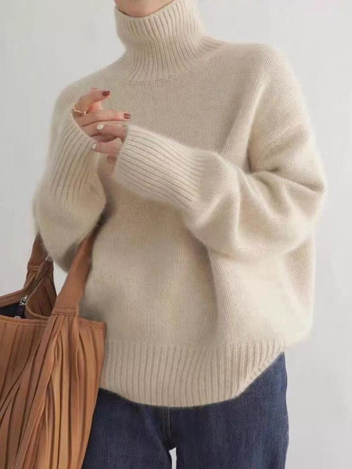 Fuzzy cream sweater styled with a woven tan tote bag