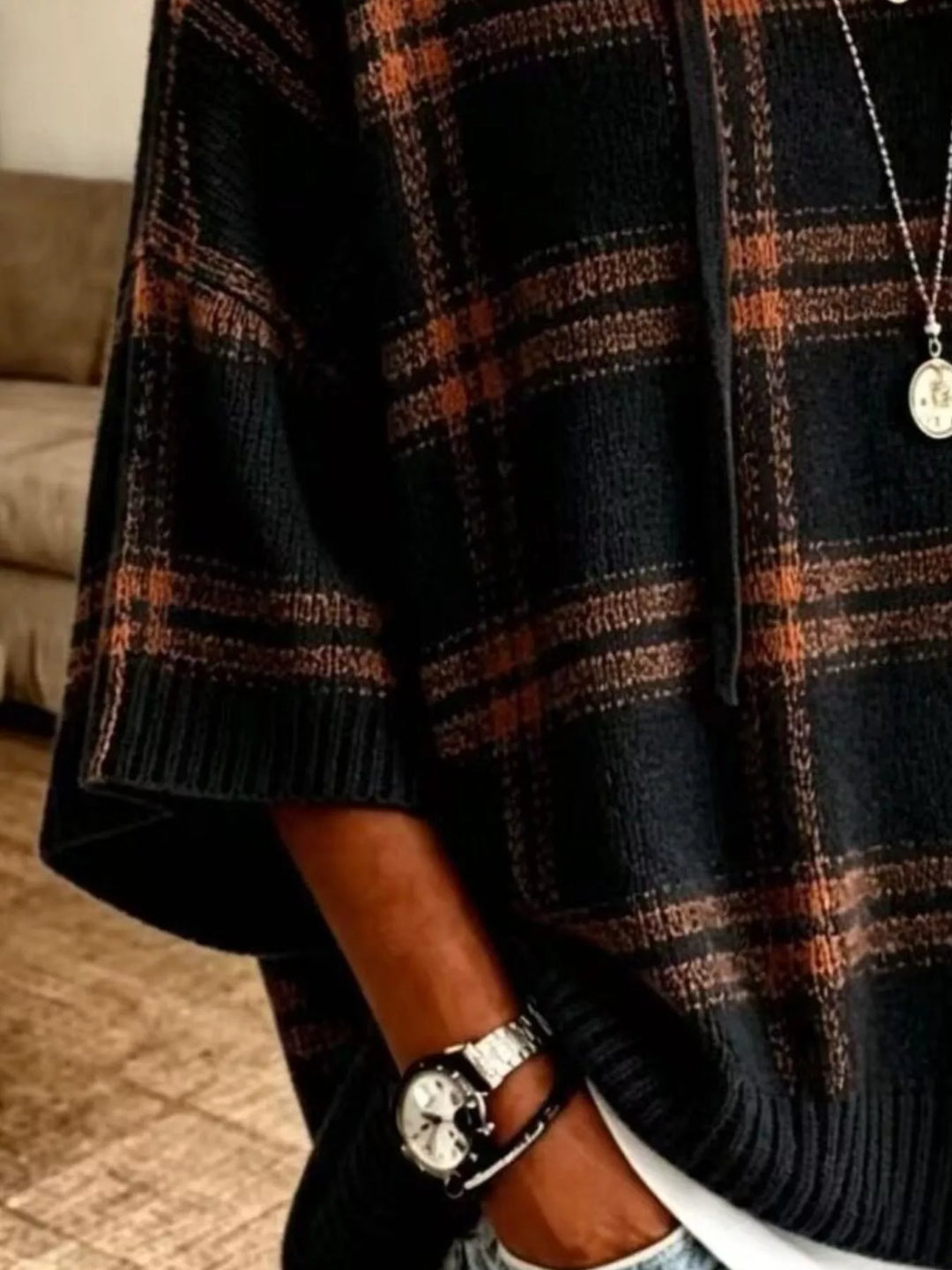 Close-up of the black plaid knit and ribbed hem on the hooded pullover