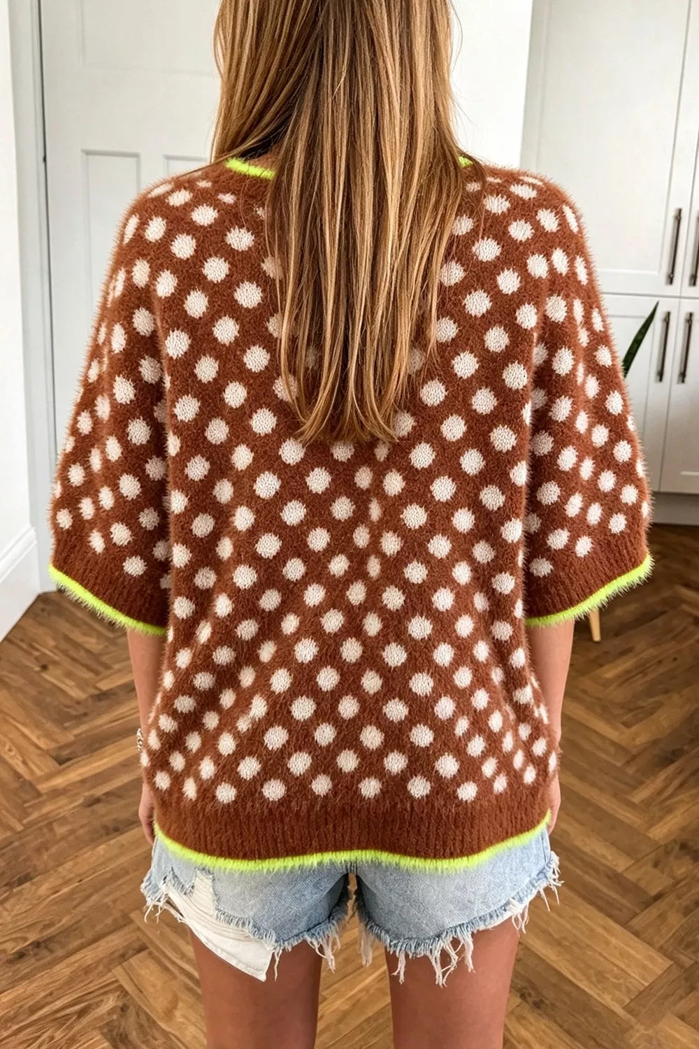 Back view of the brown polka dot loose knit sweater with green trim