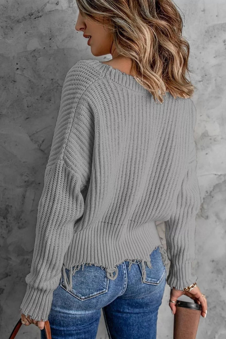 Gray drop shoulder sweater from behind with a frayed hem