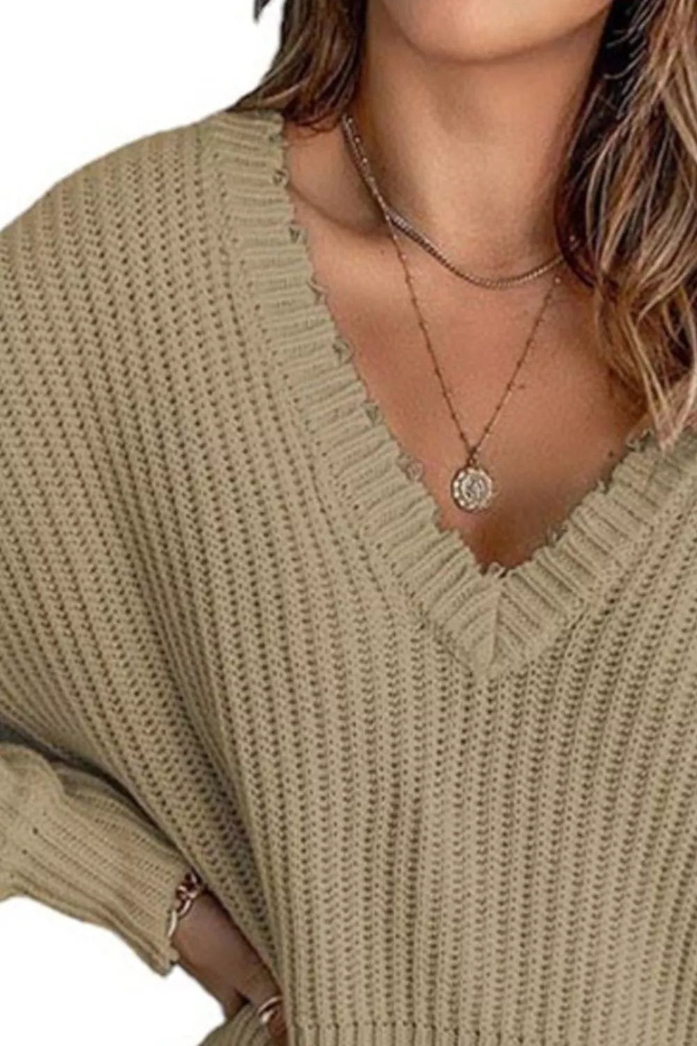 Close-up of the khaki sweater deep v-neckline and ribbed knit