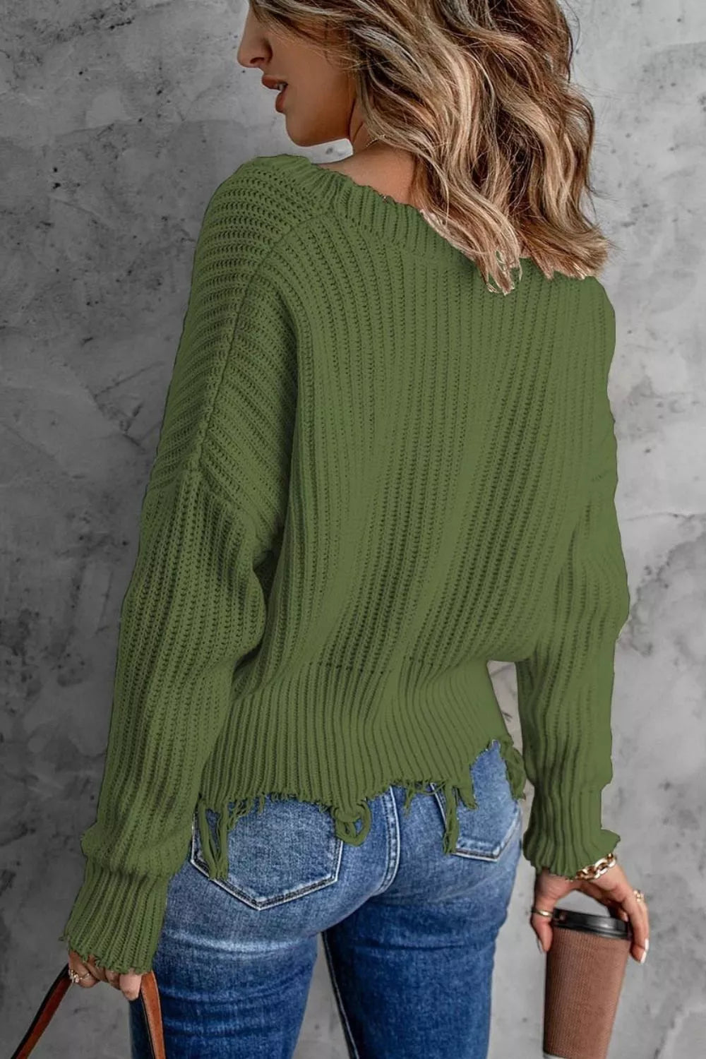 Olive green ribbed drop shoulder sweater seen from the back over jeans