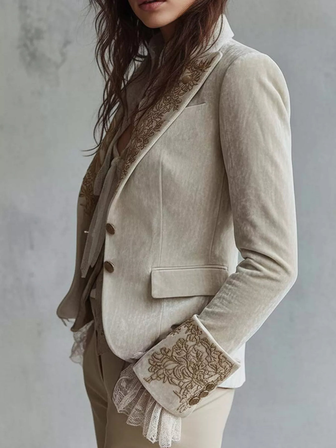 Three quarter view of the cream blazer with a flap pocket and lace cuff