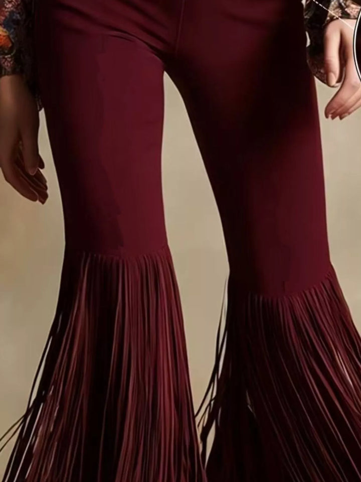Close-up of the burgundy flare pants showing the swinging fringe hem