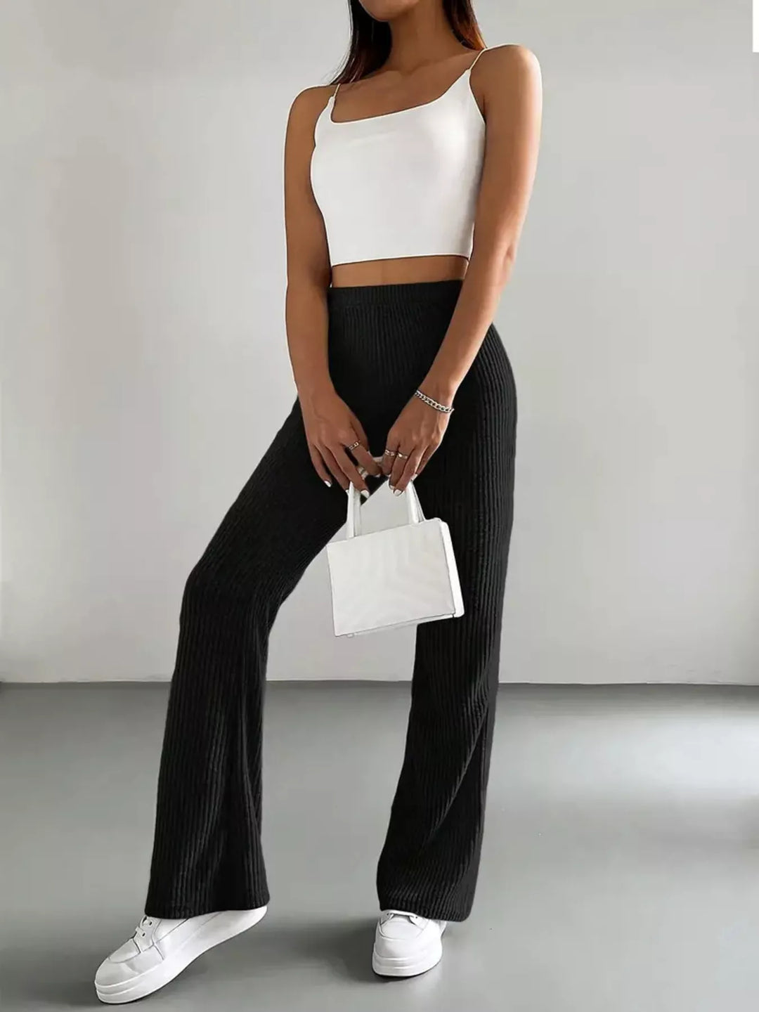 Black high waisted flare pants styled with white cami and a white handbag