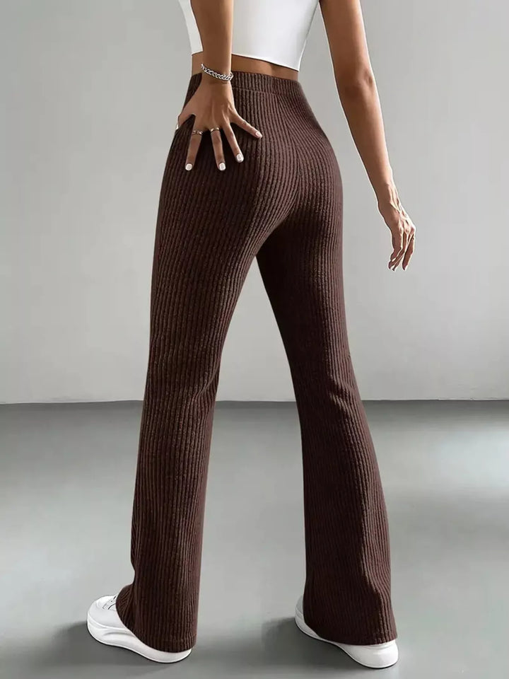 Back view of chocolate brown high waisted flare pants with hand on hip