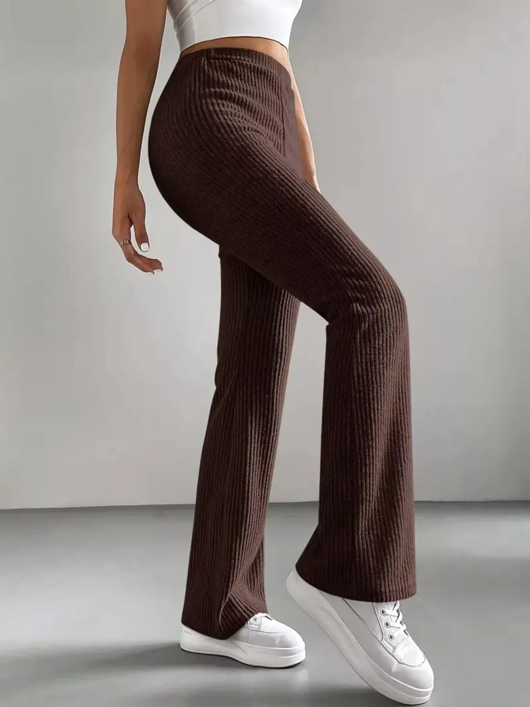Chocolate brown stretch flare pants in a walking pose, full length