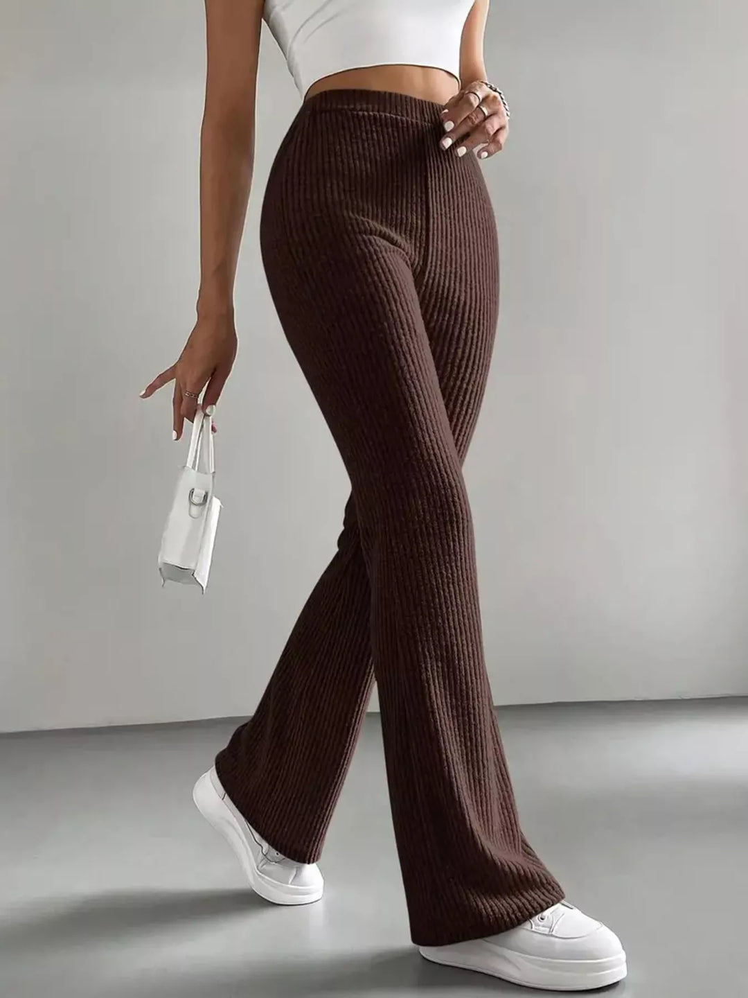 Chocolate brown ribbed flare pants front view with white sneakers
