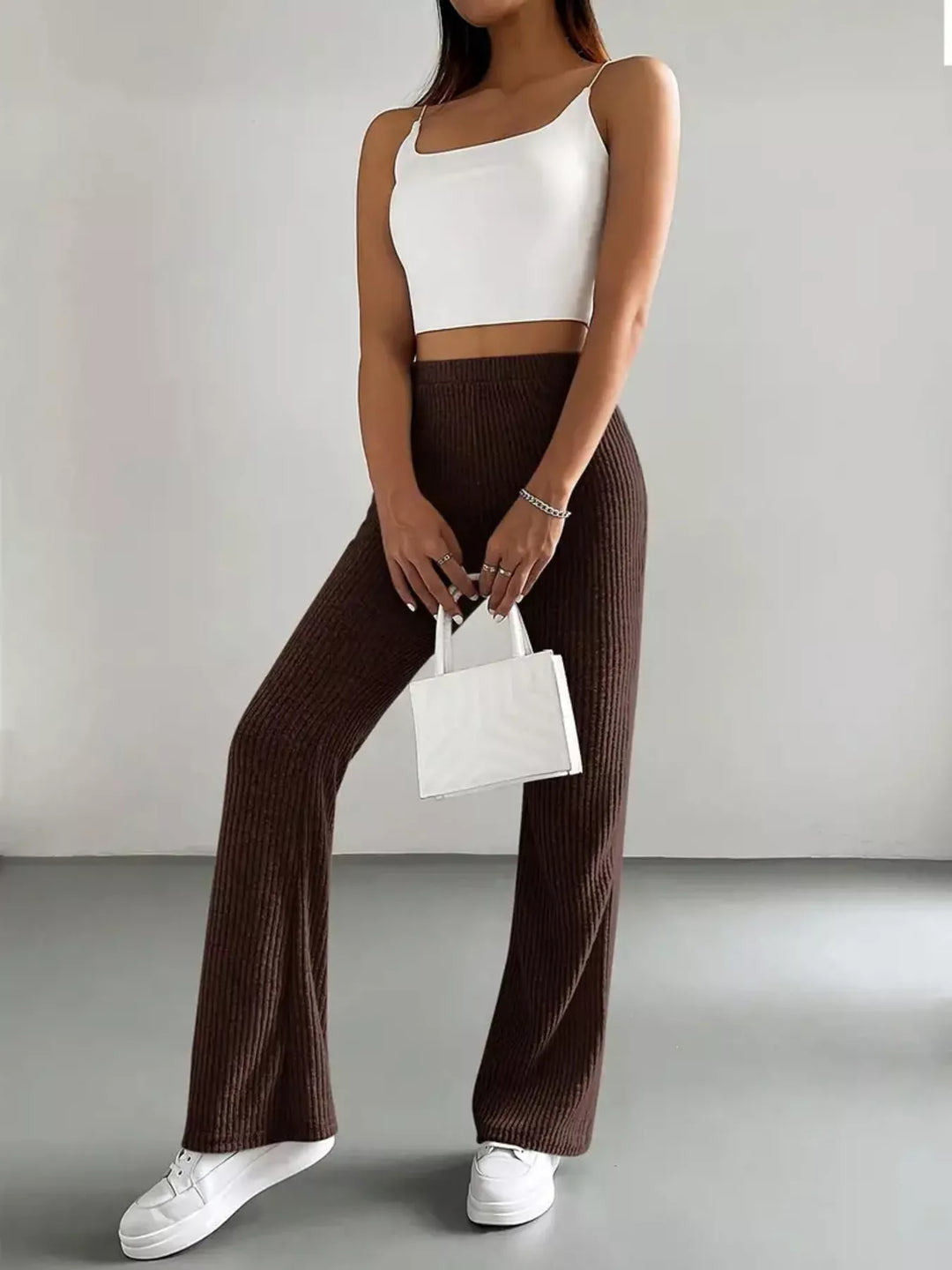 Chocolate brown flare pants styled with white cami top and white handbag