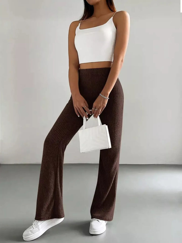 Chocolate brown flare pants styled with white cami top and white handbag