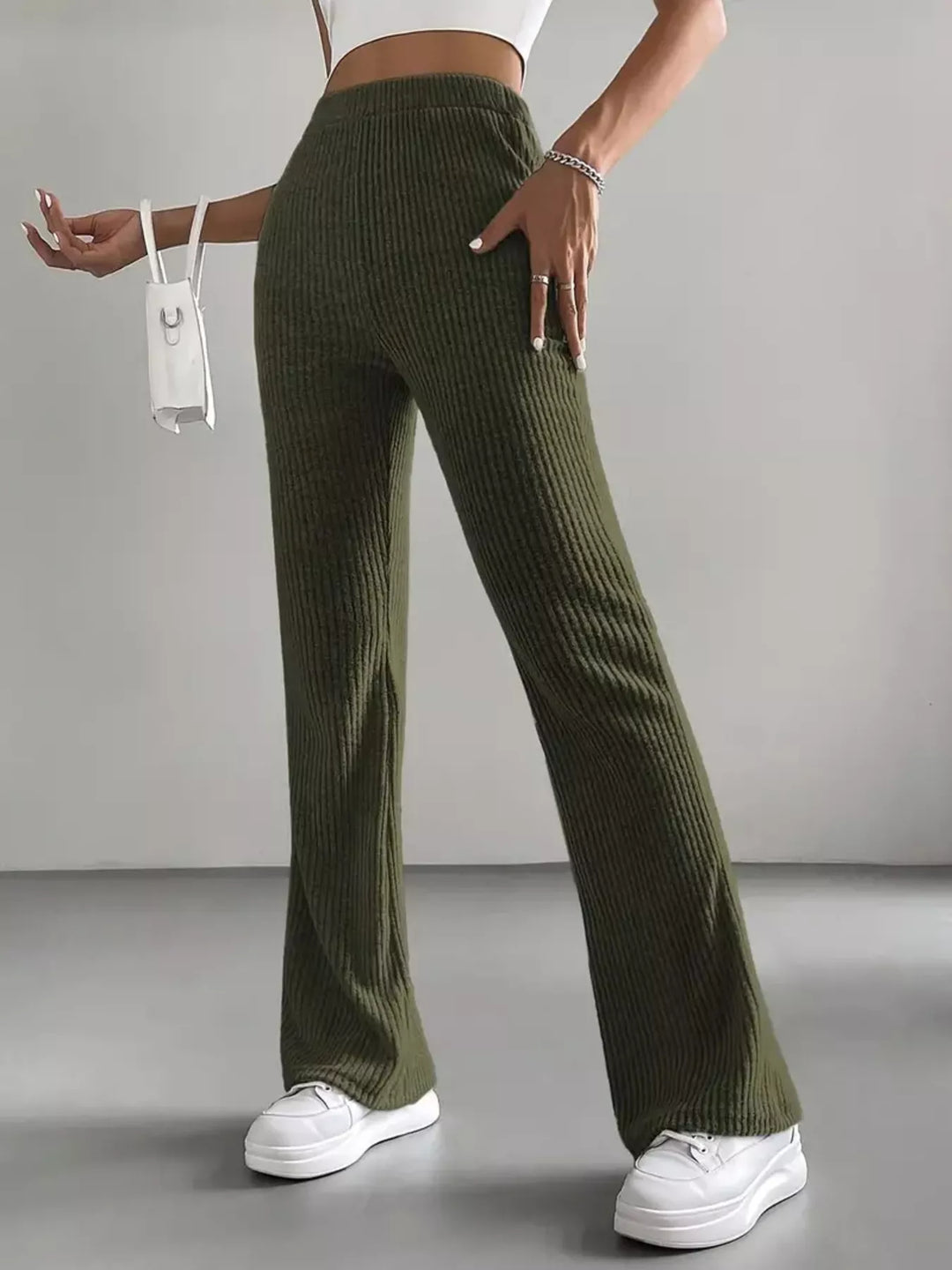 Full length view of olive green stretch flare pants and white sneakers