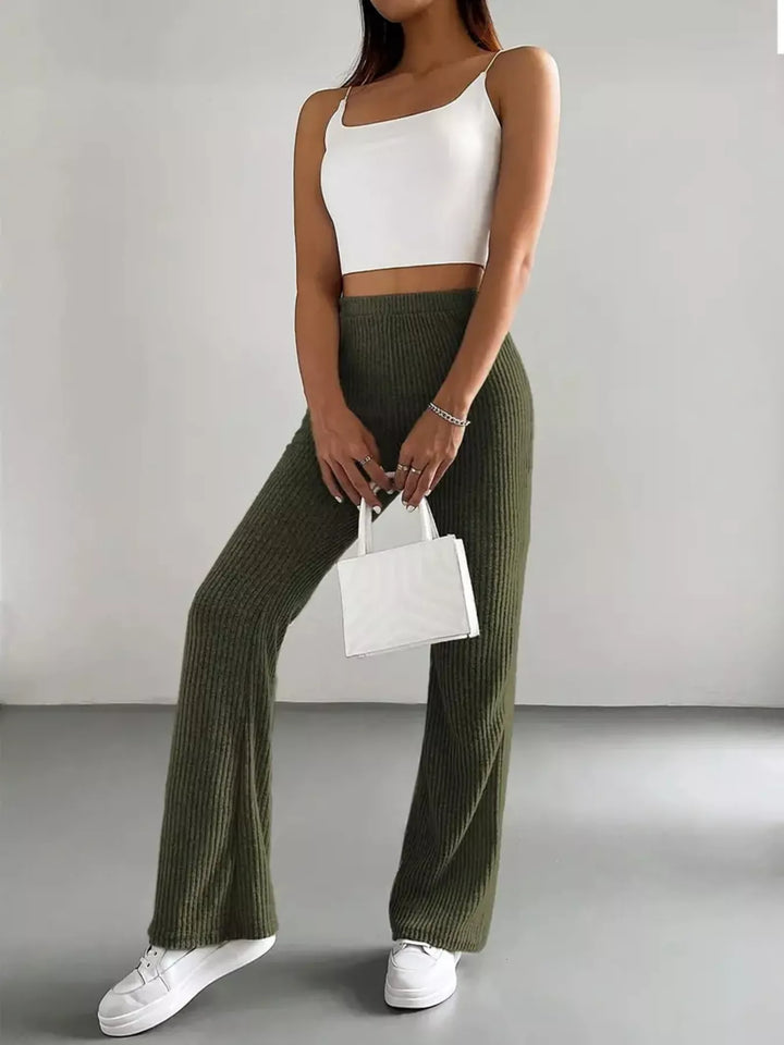 Olive green flare pants styled with white cami top and sneakers