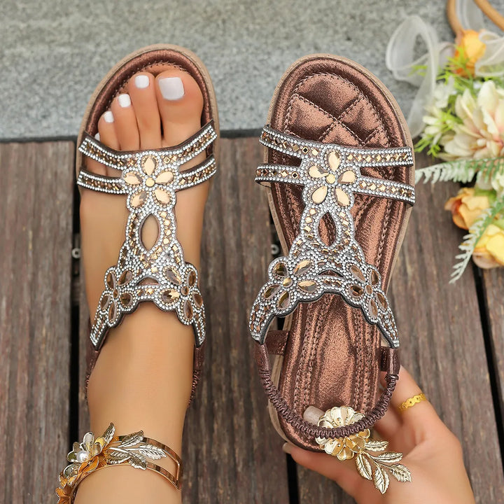 Brown flat sandals seen from above showing the padded insole and flower design