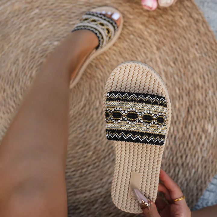 Black flat slide sandals with rope sole, top view of the footbed