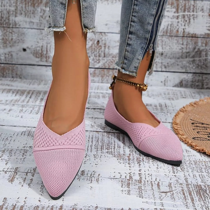 Pink pointed toe knit flats worn with ankle jeans, side view