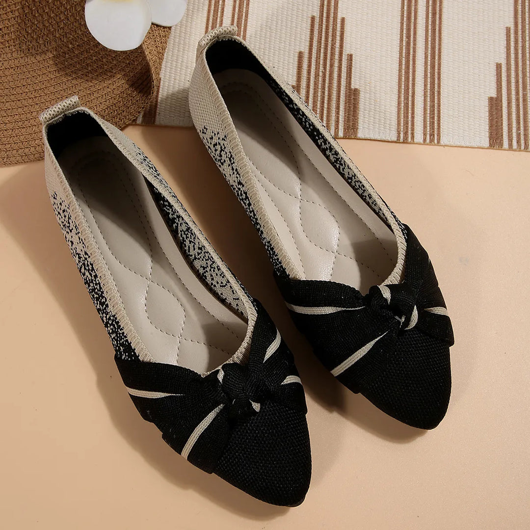 Black pointed toe flats with a knotted bow, pair seen from above