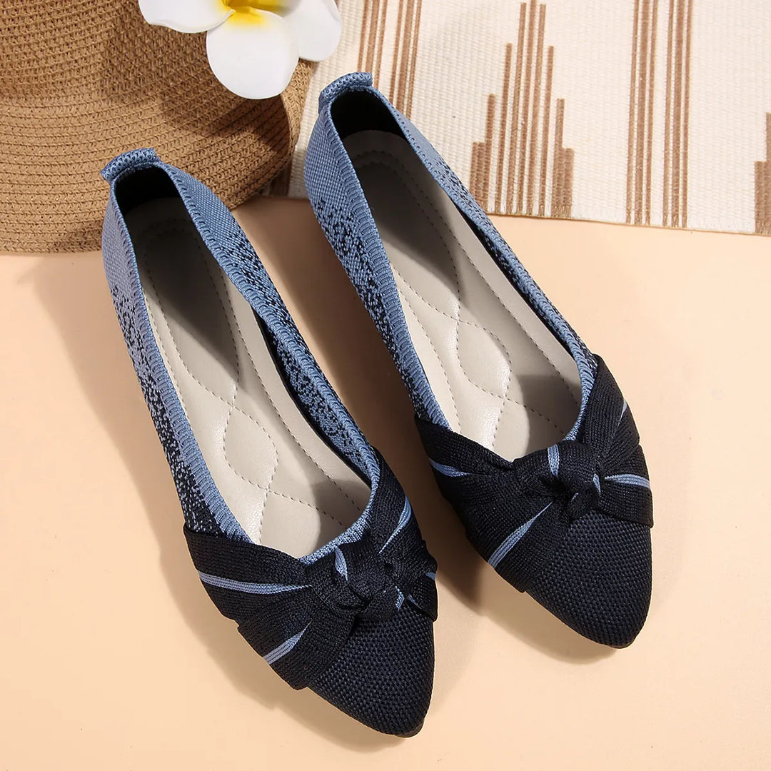Pair of navy knotted bow flats with a cushioned insole