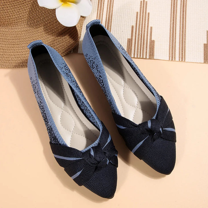 Pair of navy knotted bow flats with a cushioned insole
