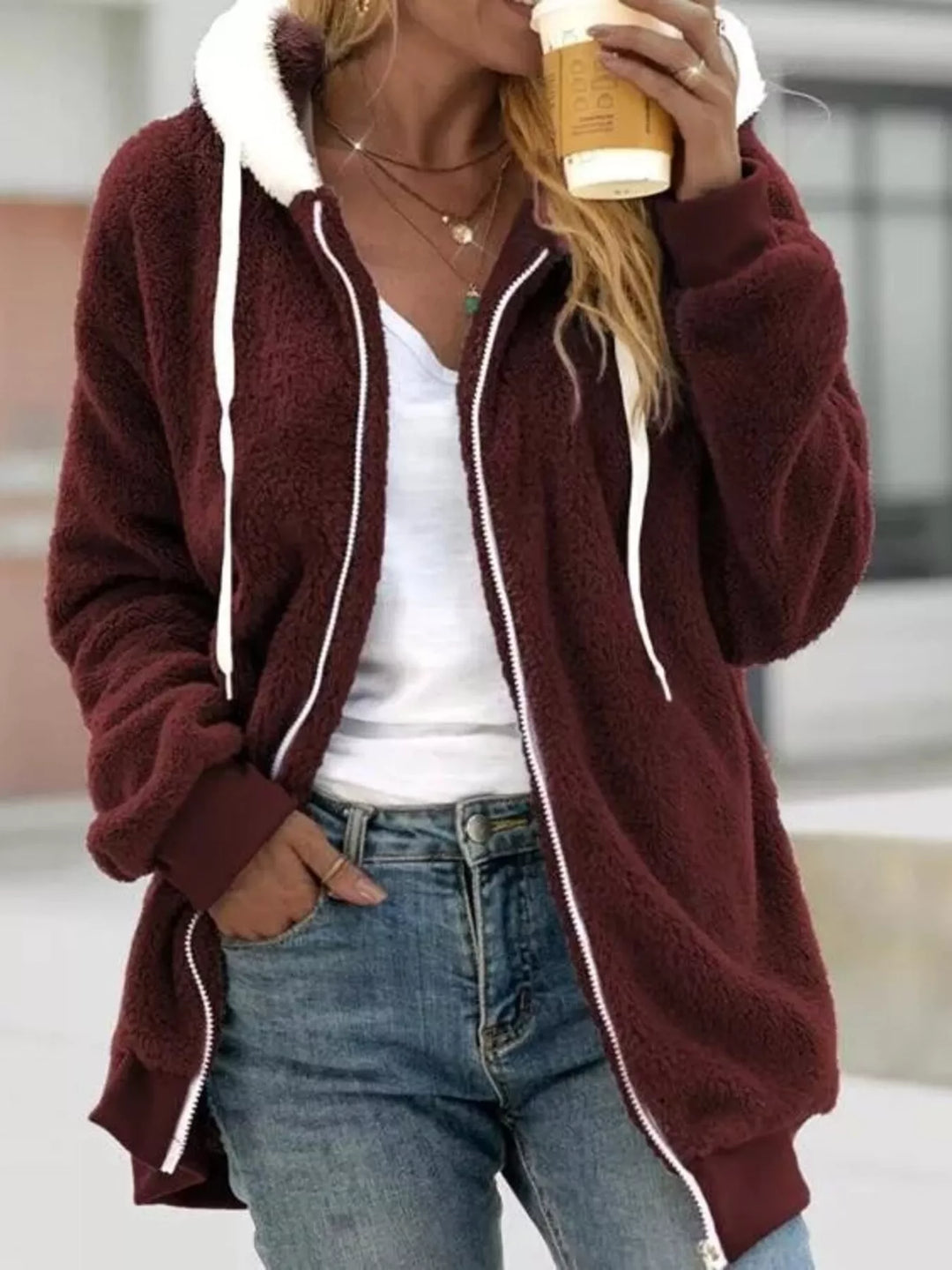 Burgundy fleece jacket with hood and white drawstrings, relaxed pose in jeans
