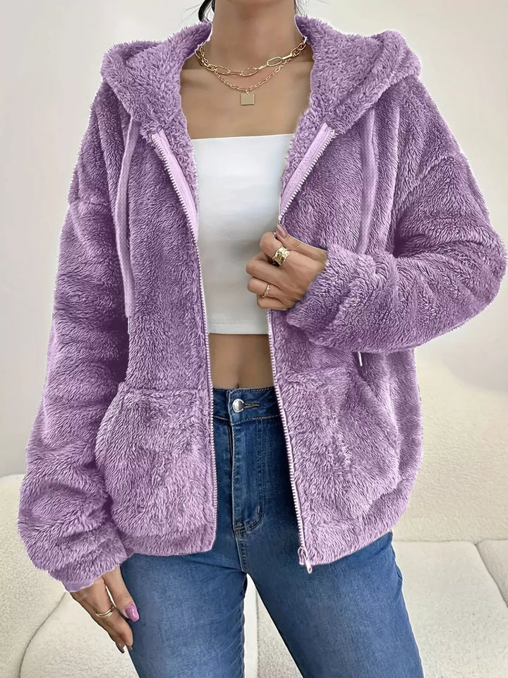 Lilac hooded zip up fleece jacket with drawstring hood over a white top and jeans