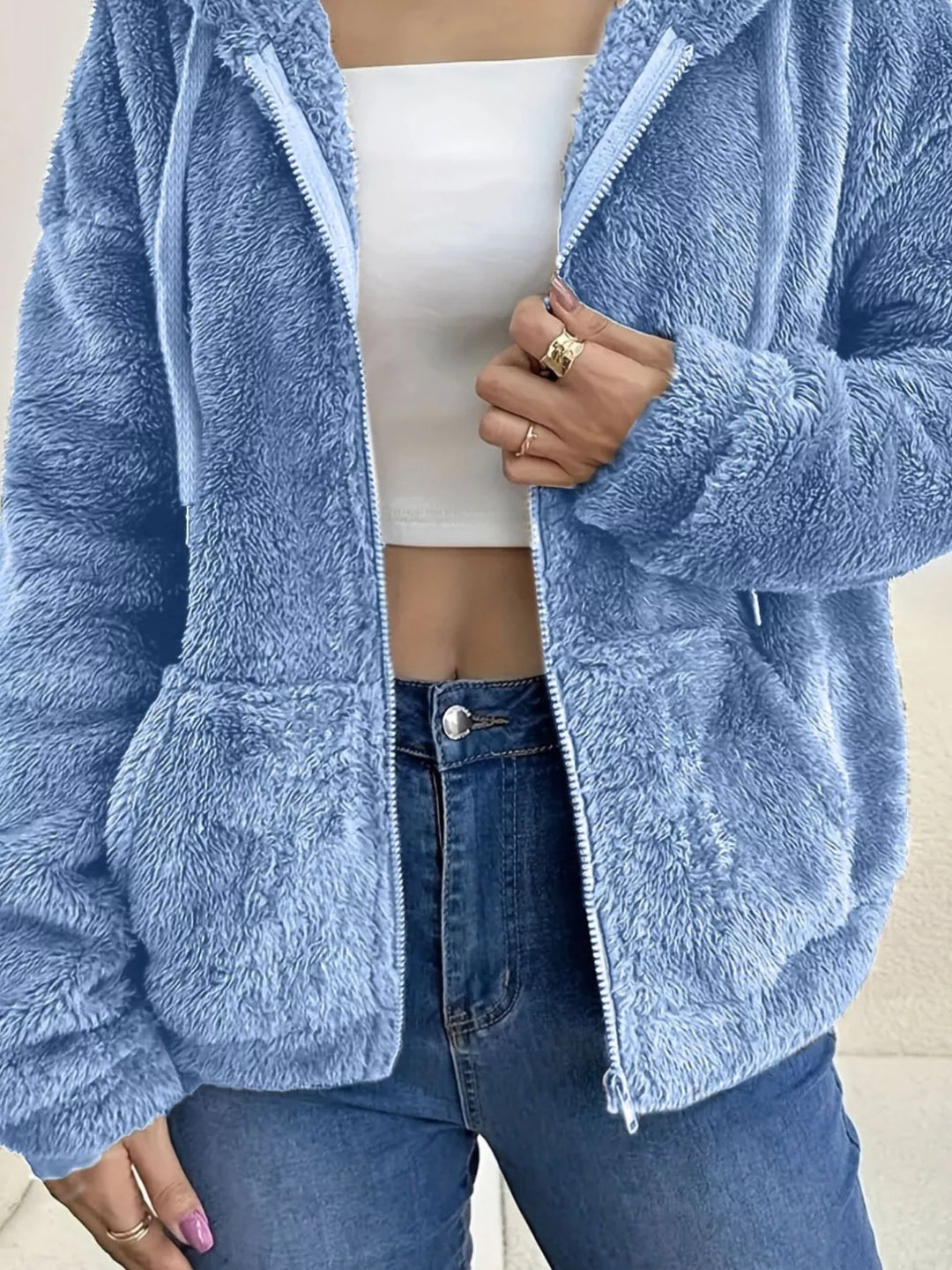 Sky blue fleece jacket pocket and sleeve texture, close-up with zipper