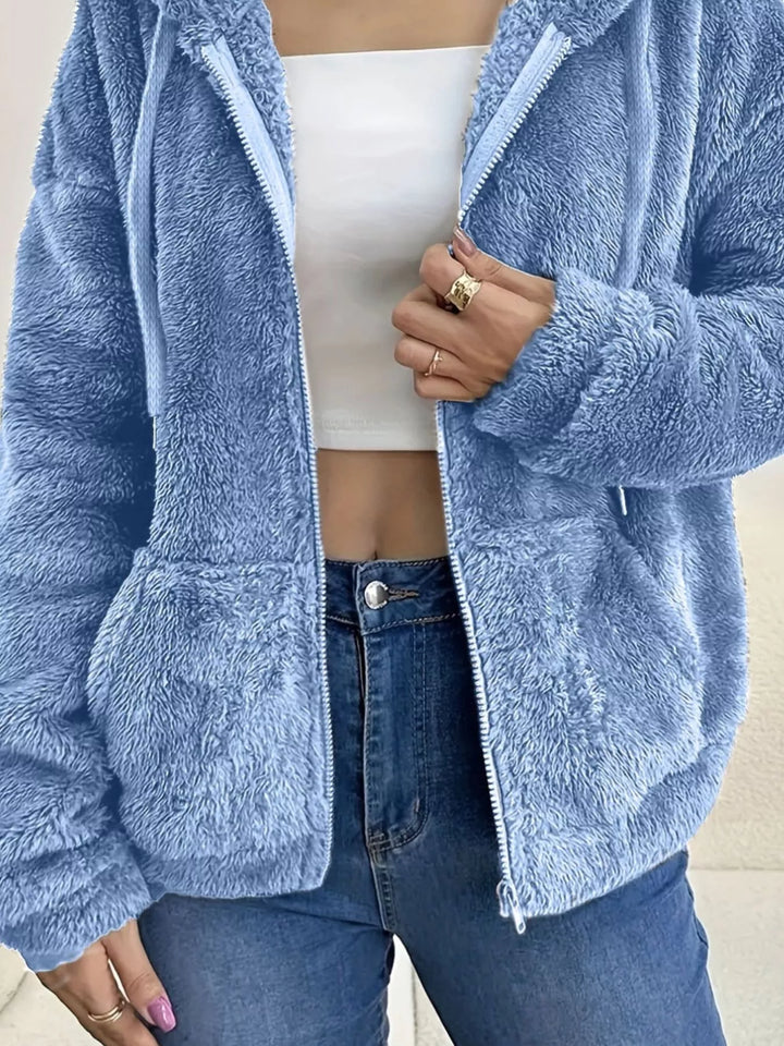 Sky blue fleece jacket pocket and sleeve texture, close-up with zipper