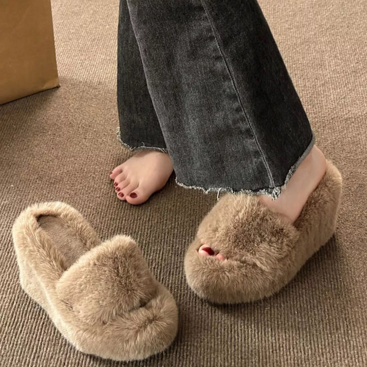 Tan fluffy platform slipper worn with frayed hem jeans, side view