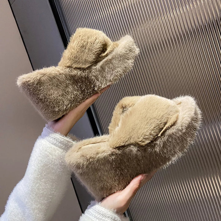 Tan crossed strap wedge slippers held in hand to show the platform sole