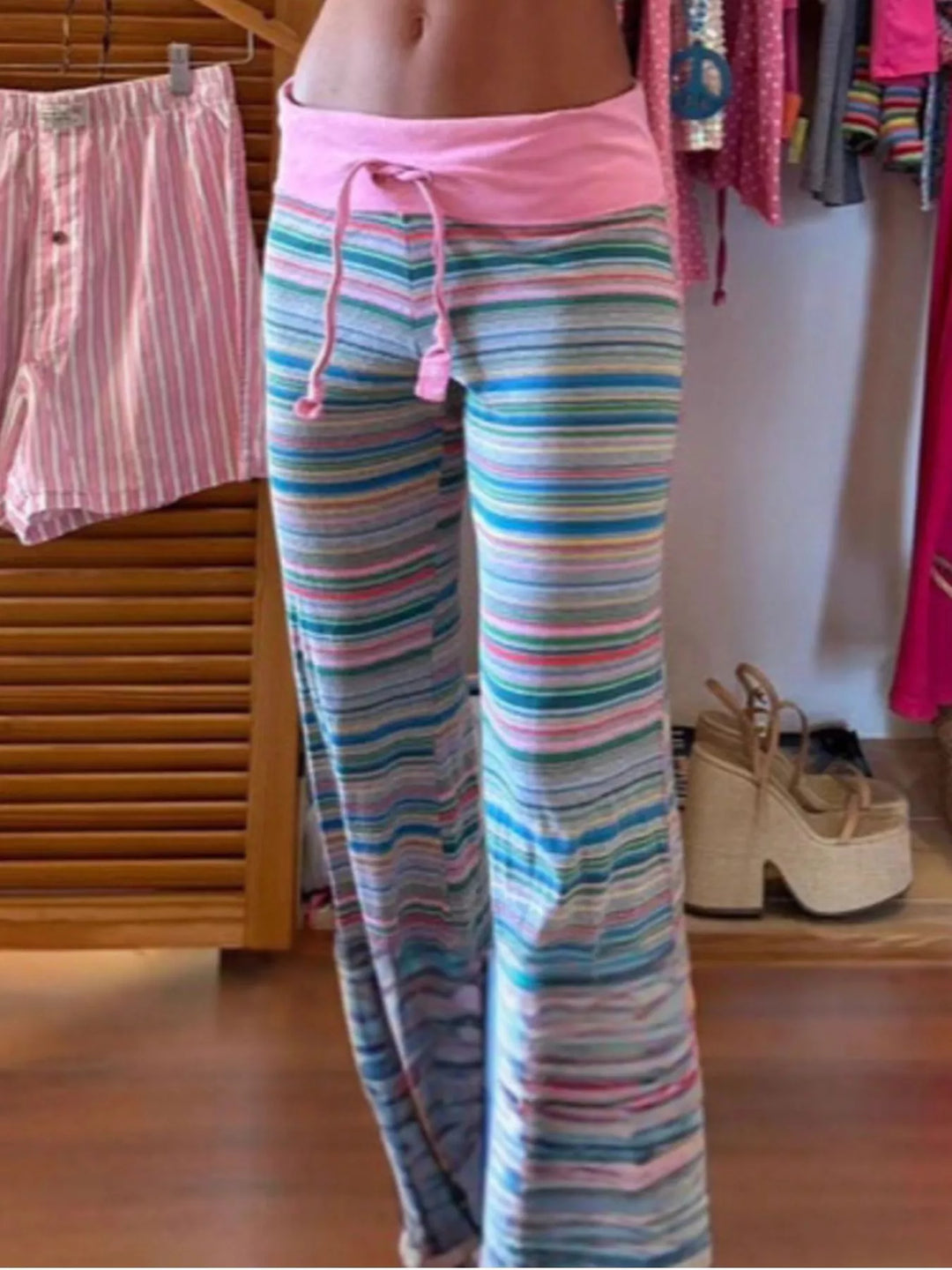 Full length view of striped flare lounge pants on a wood floor