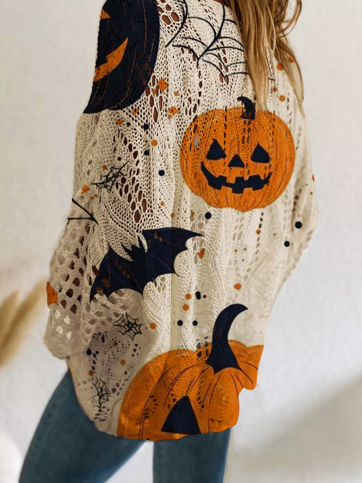 Close-up of the beige sweater pumpkin face, bats and cobweb print