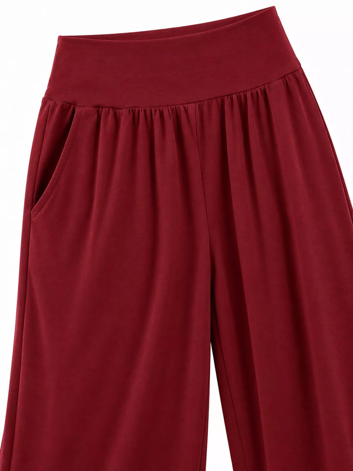 Burgundy high waisted wide leg pants, close-up of the wide smocked waistband and pocket