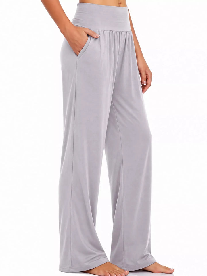 Light gray high waisted wide leg pants, side view with pocket and bare feet