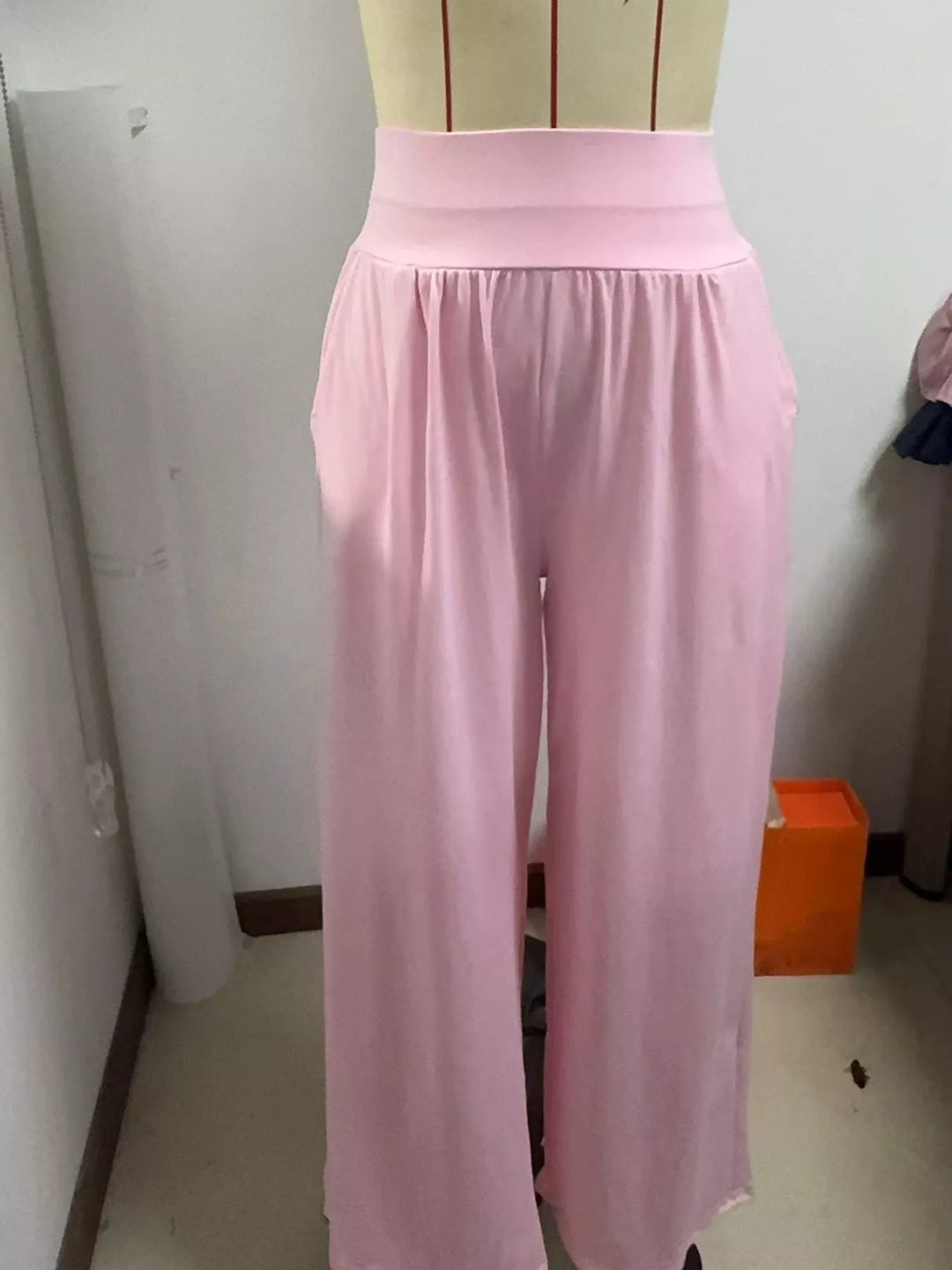 Light pink high waisted wide leg pants, shown indoors with the gathered waistband