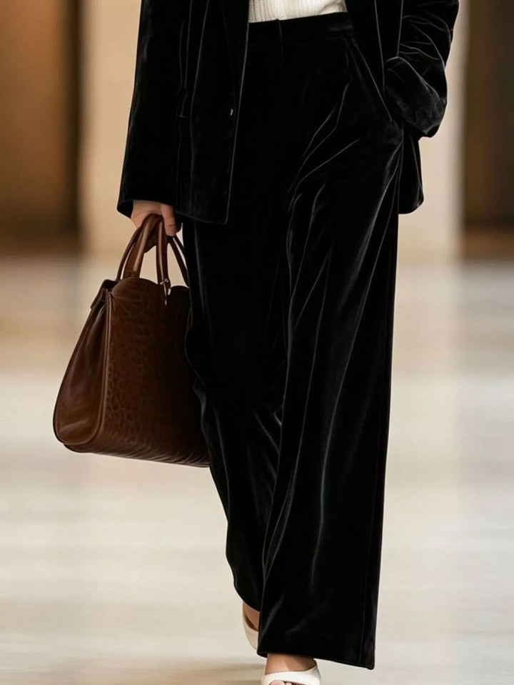 Black wide leg pants and blazer, close view of the velvet-look fabric and tote