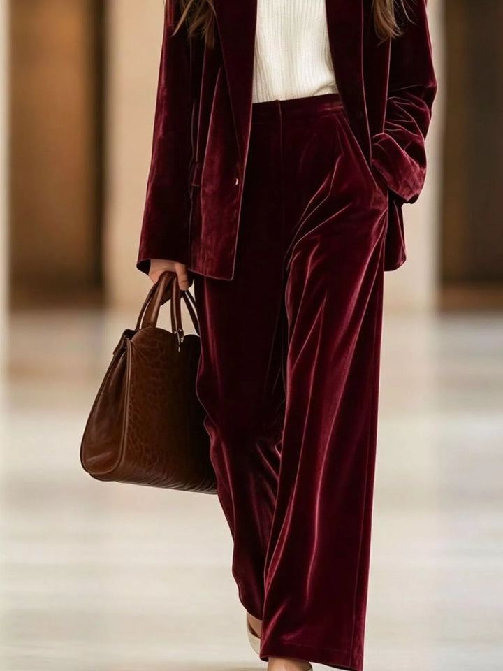 Burgundy wide leg pants and blazer, close view with a brown tote bag