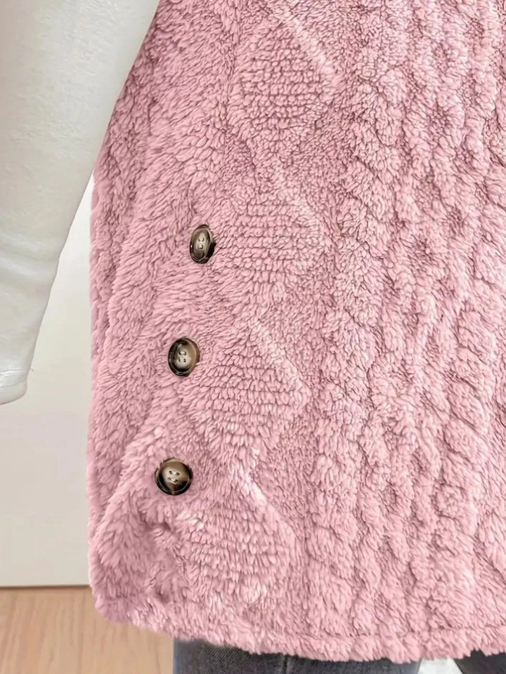 Close-up of the side buttons on the blush pink cable knit vest