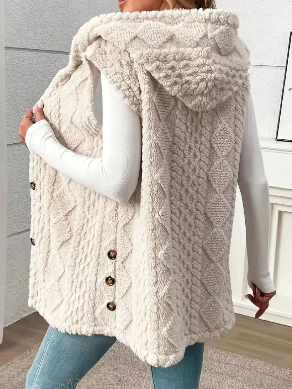Cream hooded cable knit vest with the hood up and side buttons