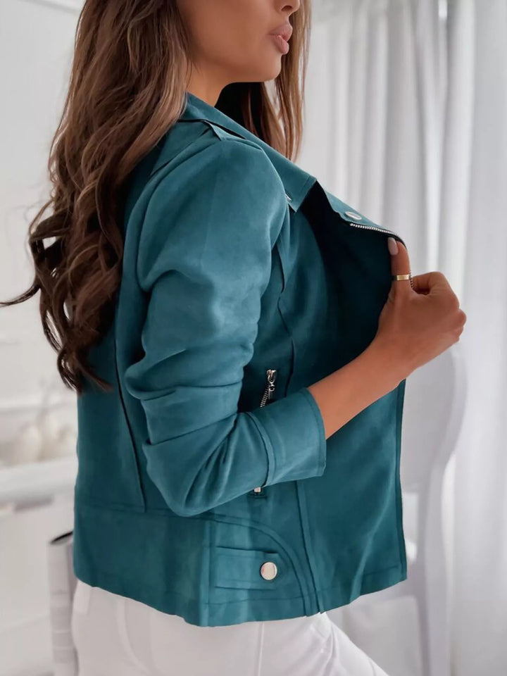 Deep teal moto style jacket seen from the side, hand at the lapel