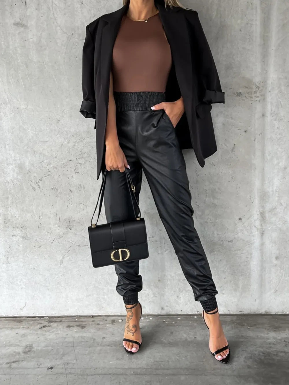 Black high rise jogger pants worn with a blazer and strappy heels