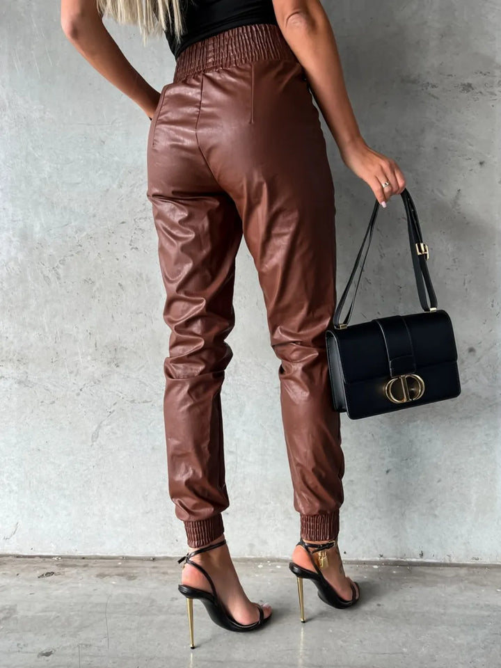Back view of chestnut jogger pants with smocked waist, worn with heels