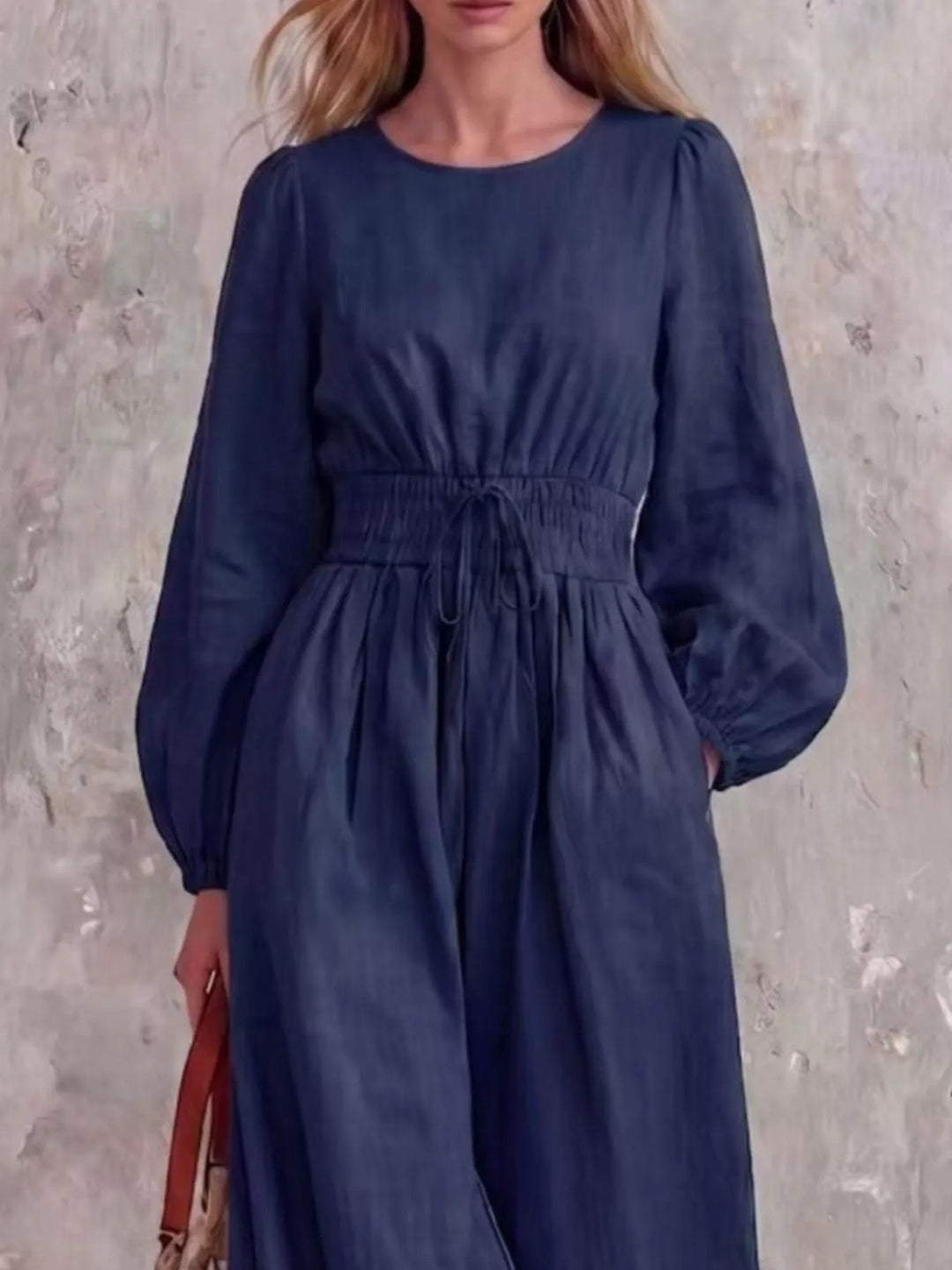 Navy jumpsuit with cinched waist and balloon sleeves, three quarter view