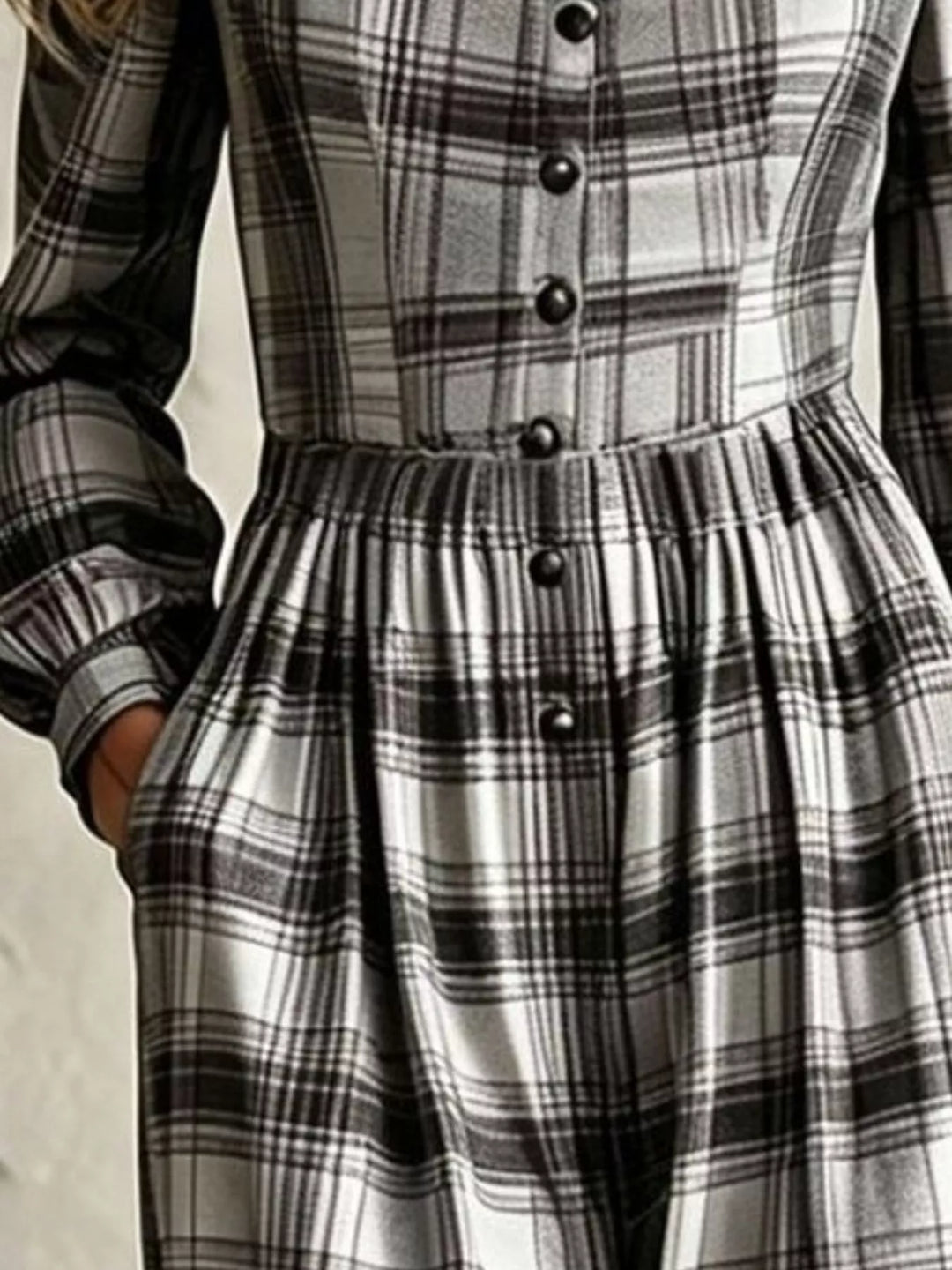 Close-up of black and white plaid jumpsuit buttons and pleated waist